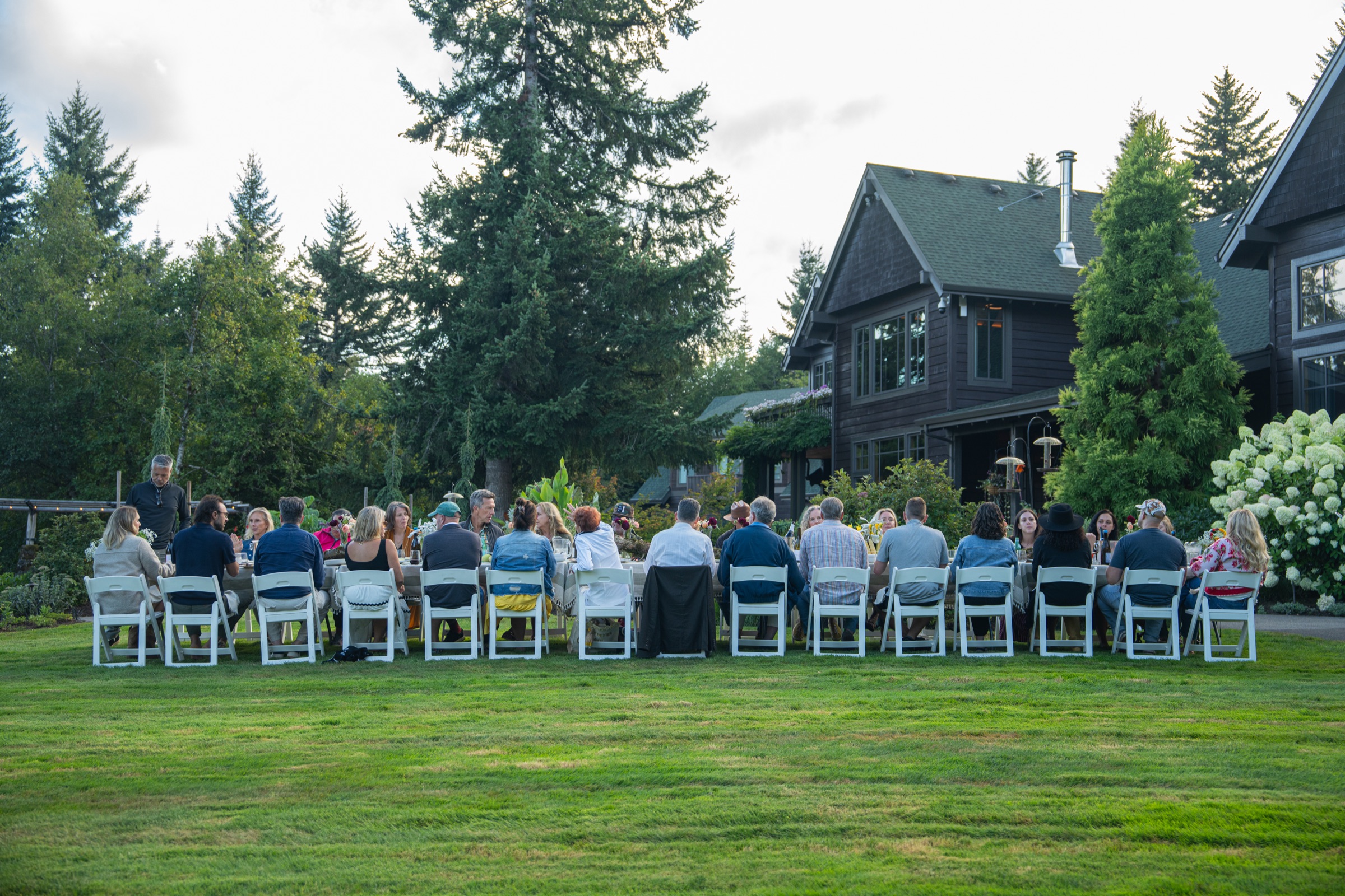 The long gathering table set on the lawn with the retreat house in the background